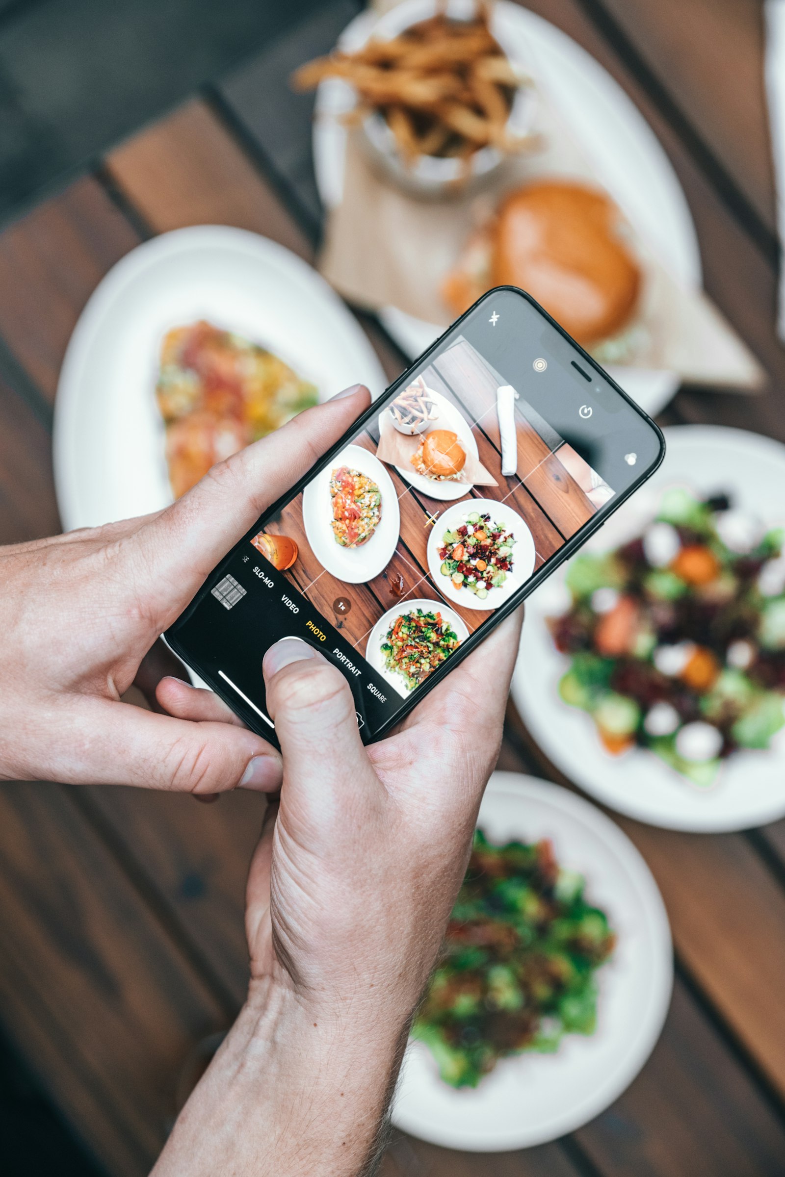 Cliente usando o celular em um restaurante para visualizar o cardápio digital